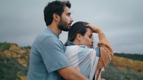 Tender-couple-posing-nature-standing-in-front-gloomy-cloudy-sky-together-closeup