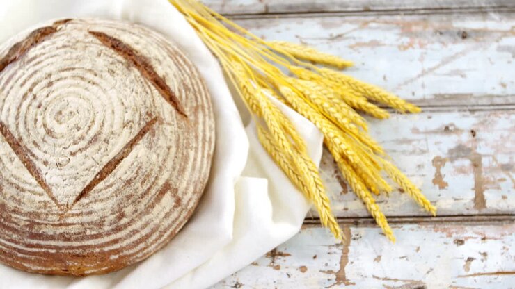 Sourdough with wheat grains on wooden table
