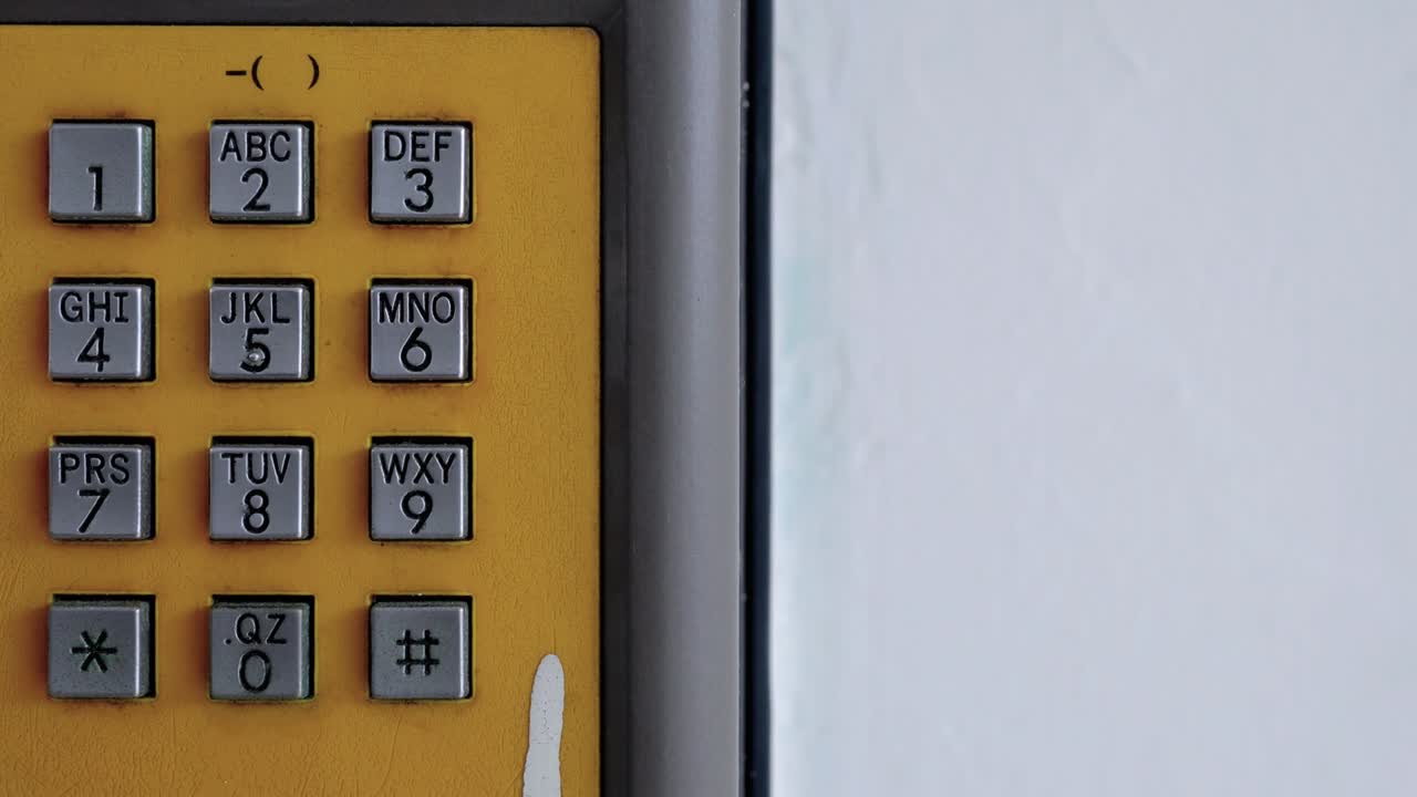 Closeup of public phone buttons. The subject is on the left.
