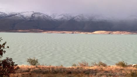 A-glacial-river-flows-beneath-foggy-mountains