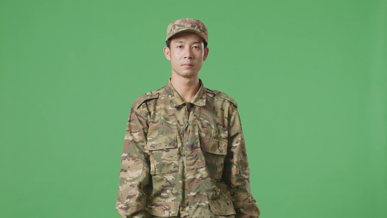 녹색 스크린 배경 스튜디오에서 걸어가는 아시아인 군인