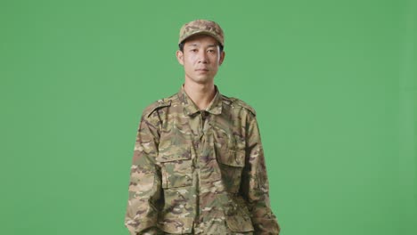 hombre asiático soldado caminando en la pantalla verde estudio de fondo