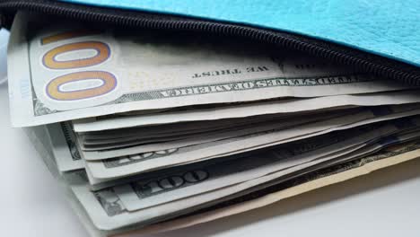 money in a teal zippered bag