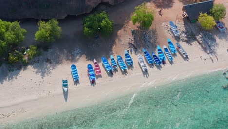 Aerial-top-down-lowering-over-Cueva-de-los-Pescadores-and-row-of-boats,-Pedernales