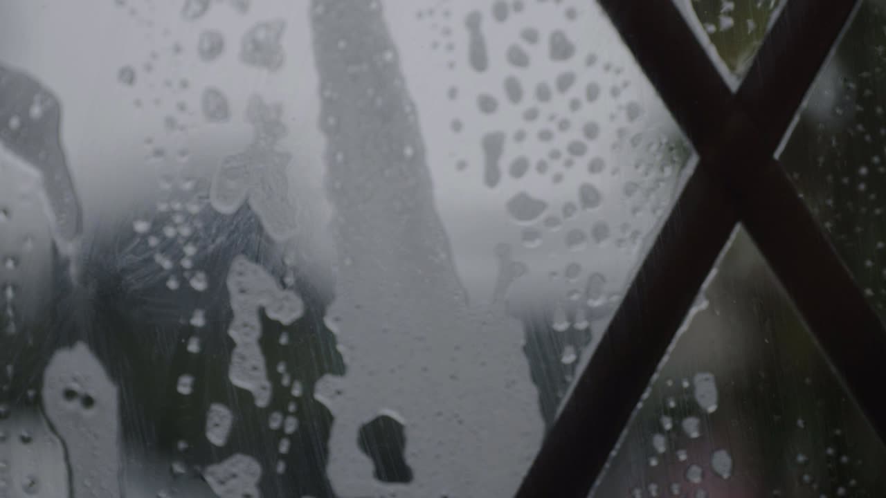 Soapy suds falling slowly down leaded window