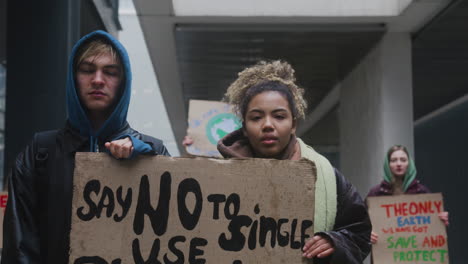 Junge-Männliche-Und-Amerikanische-Aktivistinnen-Halten-Während-Eines-Protestes-Gegen-Den-Klimawandel-Ein-Plakat-Aus-Pappe,-Während-Sie-Auf-Kamera-1-Schauen