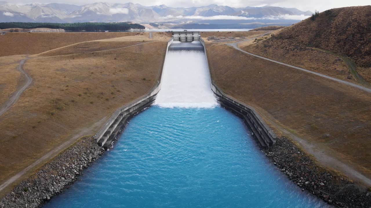 Opened Lake Pukaki dam spilling vast amounts of glacial melt water into blue river