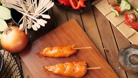 Slow-panning-shot-of-chicken-skewers-surrounded-by-vegetables