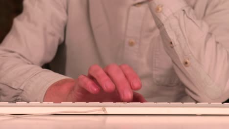 persona frustrada tocando los dedos y escribiendo en un teclado blanco