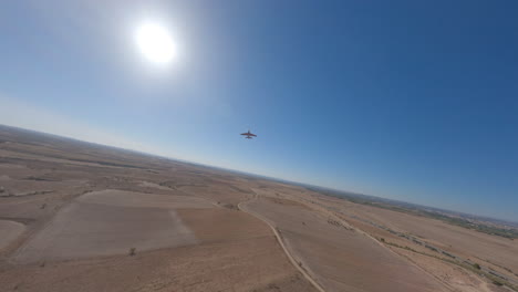 fpv drone tracking rc plane haciendo maniobras extremas en un día soleado