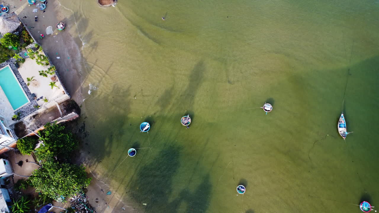 둥근 보트가 있는 녹색 물에 있는 작은 해변 위로 공중 상향식 전망