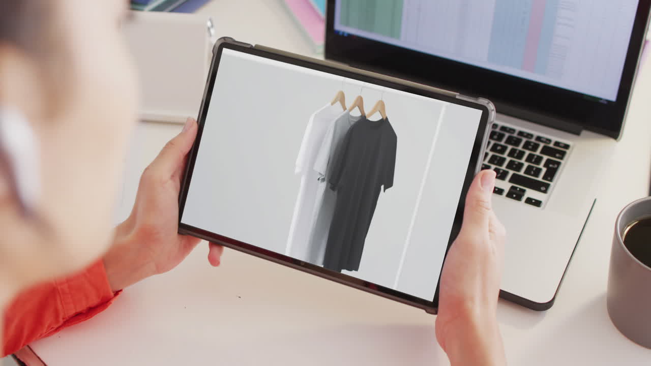 태블릿을 이용해 책상에 앉아 있는 백인 여성, 온라인에서 옷을 구입하는 것, 느린 동작