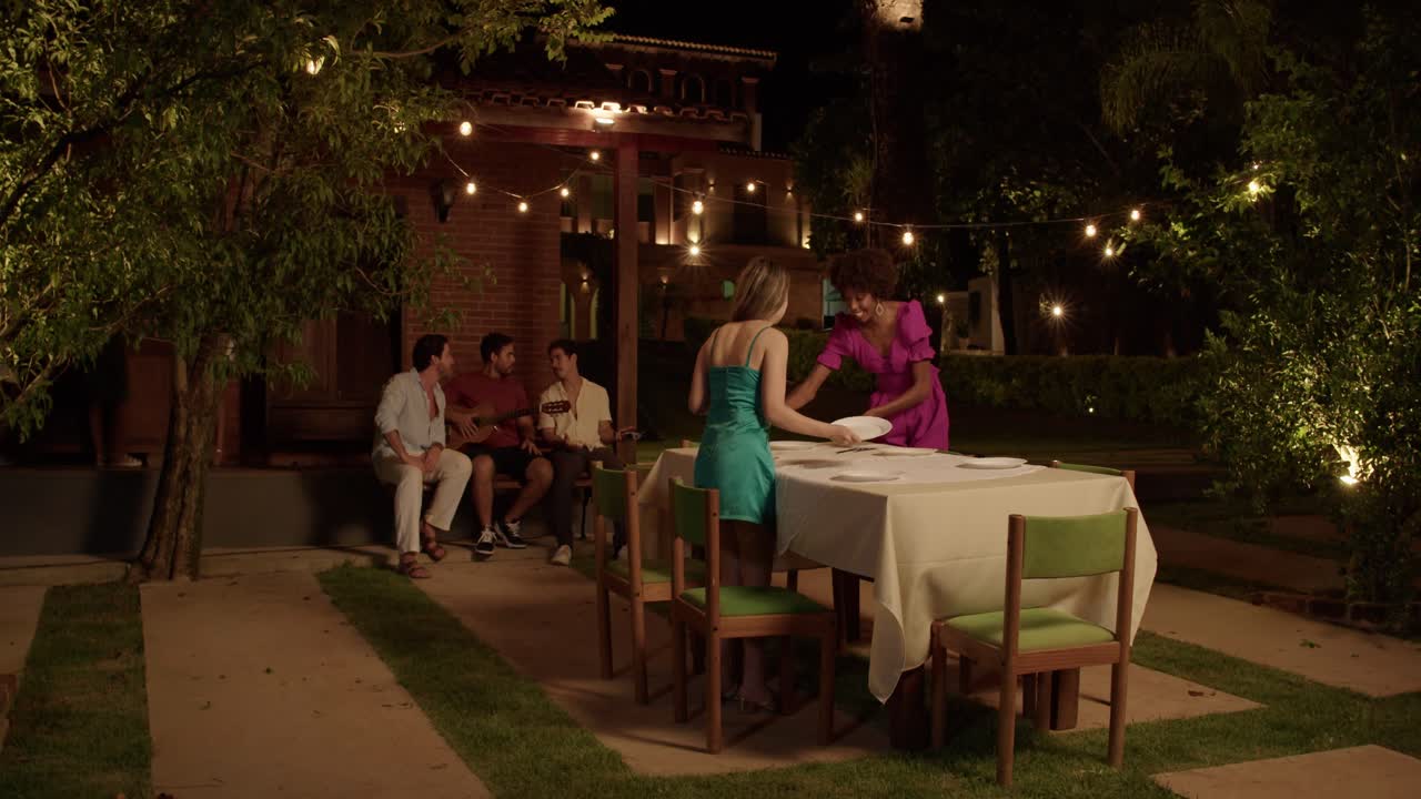 Friends Enjoying a Lively Outdoor Dinner Party at Night