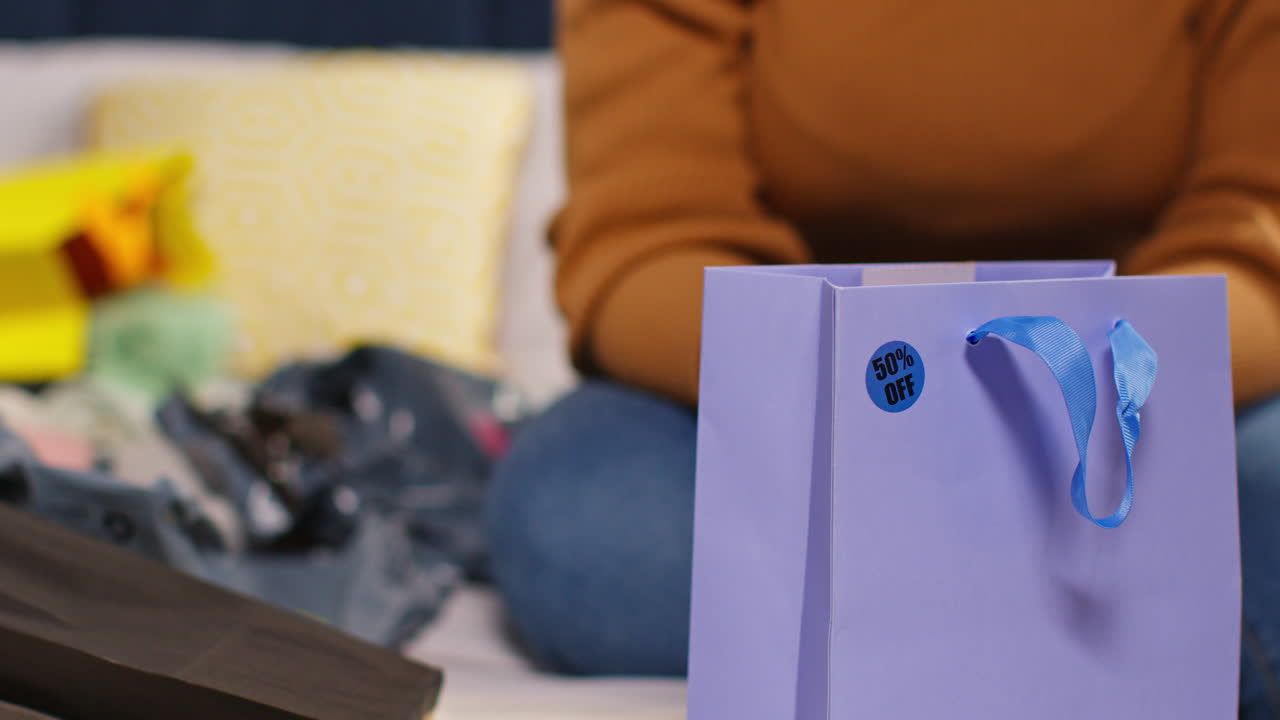 쇼핑 가방 을 들고 침대 에 앉아 있는 여자