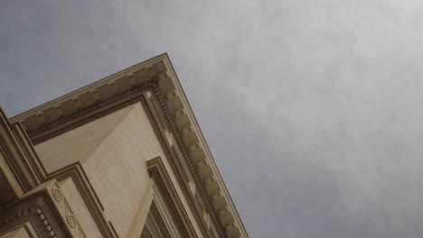 Looking-up-at-the-exterior-brick-architecture-of-a-1900's-mansion-with-sky-and-clouds-in-background