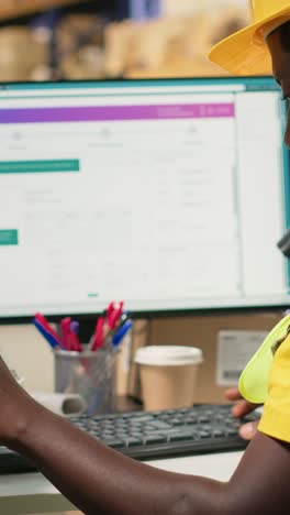 vertical video black depot clerk reviewing inventory data on tracking software