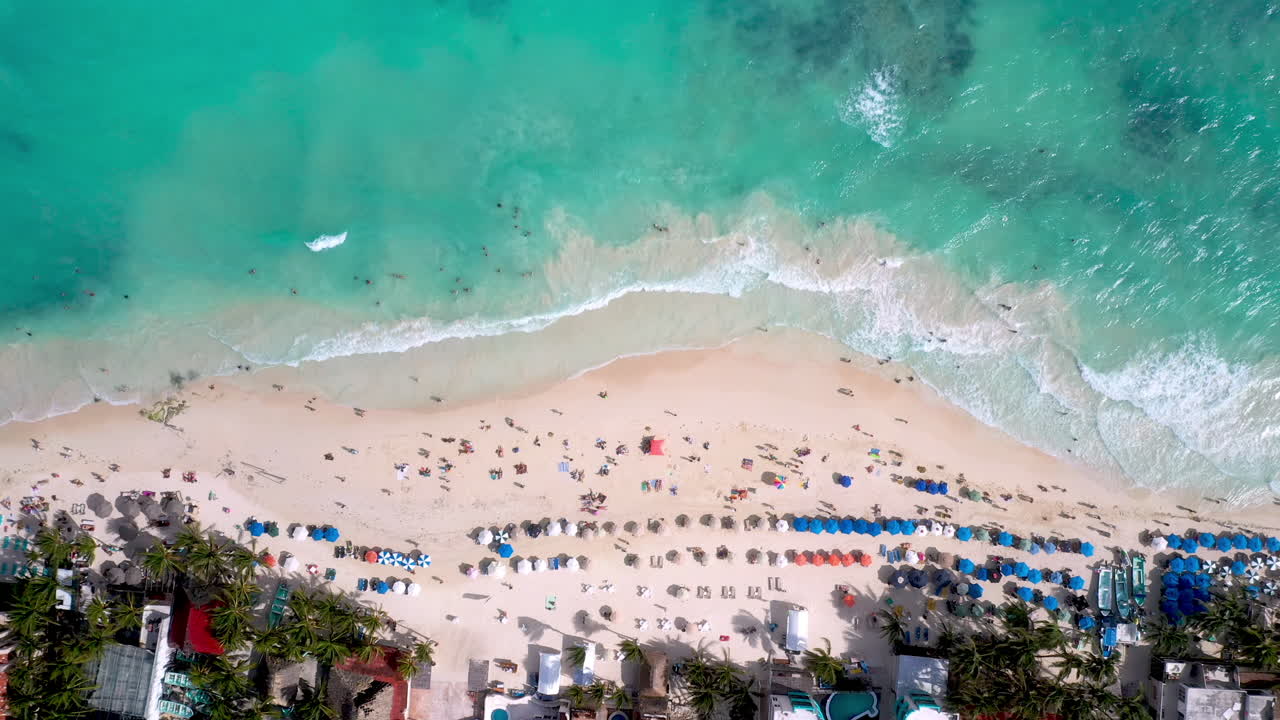 Ripresa cinematografica con drone in discesa che si avvicina alle persone sulla spiaggia a Playa Del Carmen, Messico