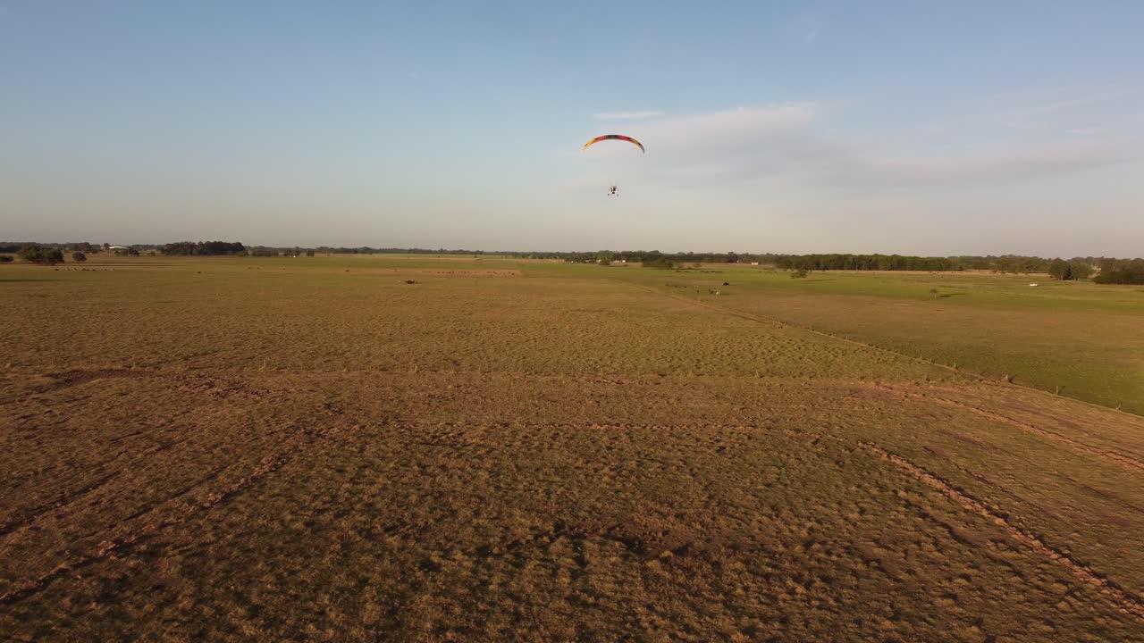 vista trasera del despegue del parapente motorizado sobre el campo, argentina