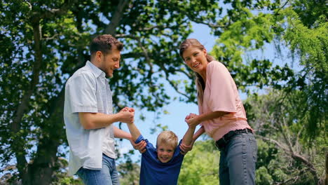 un hombre y una mujer balanceando a un niño