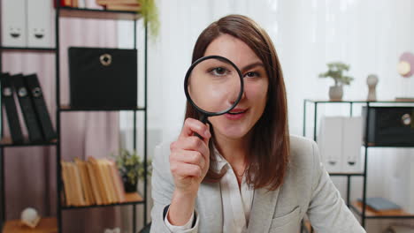 Investigator-researcher-businesswoman-looking-through-magnifying-glass-with-wow-expression-analyzing