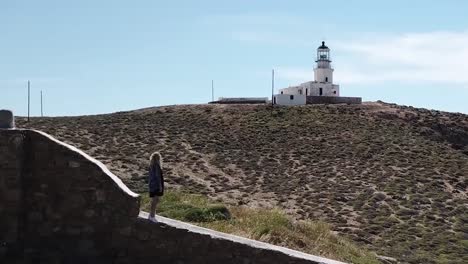 aerial drone on woman standing in front of lighthouse parallax