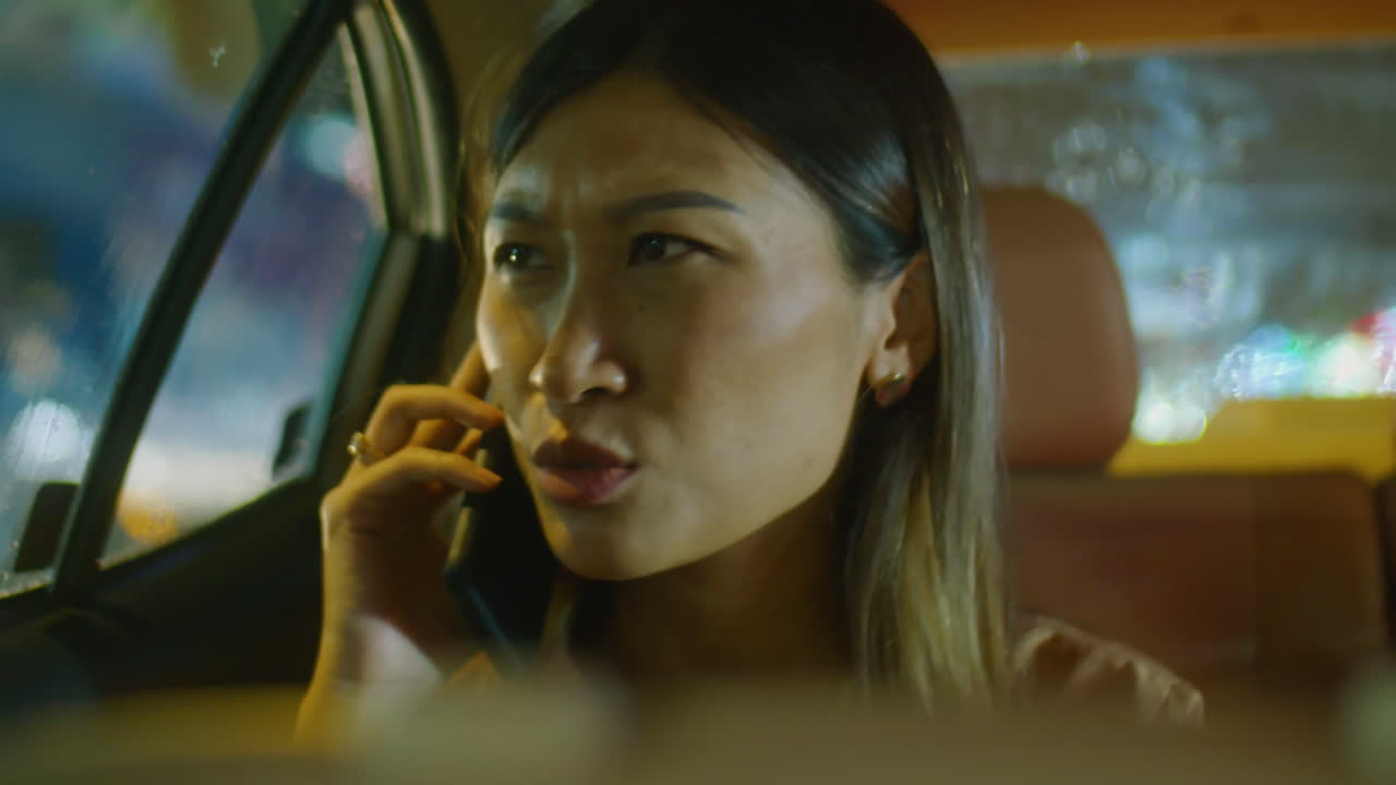 Asian Woman Speaking on Phone in Car at Night