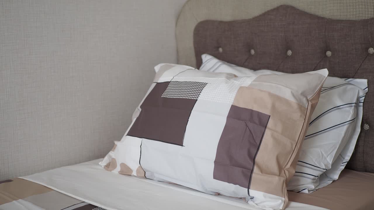 уютная спальня с подушками с геометрическим рисунком