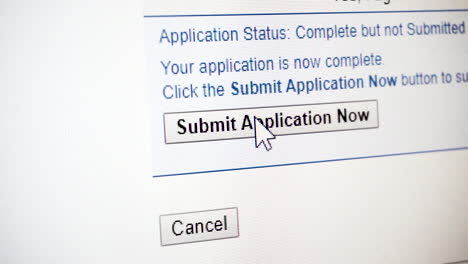 Close-up-of-mouse-clicking-'Submit-Application-Now'-button-on-computer-monitor