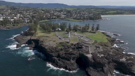 aerial panoramic establishing orbit above rocky peninsula with lighthouse in kiama nsw australia