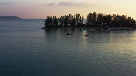 vista aérea cinematográfica drone vuela alrededor del paraíso 101 y la isla de seratos capturando velero amarrado en el agua contra el hermoso cielo del atardecer en langkawi, kedah, malasia, sudeste de asia