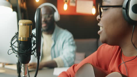 african american woman recording song with sound producer
