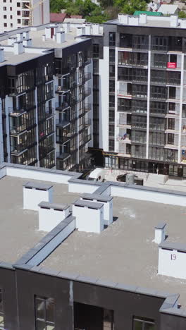 modern city complex with a playground. flight over high residential complex with modern buildings. new infrastructure in the city. aerial view. vertical video