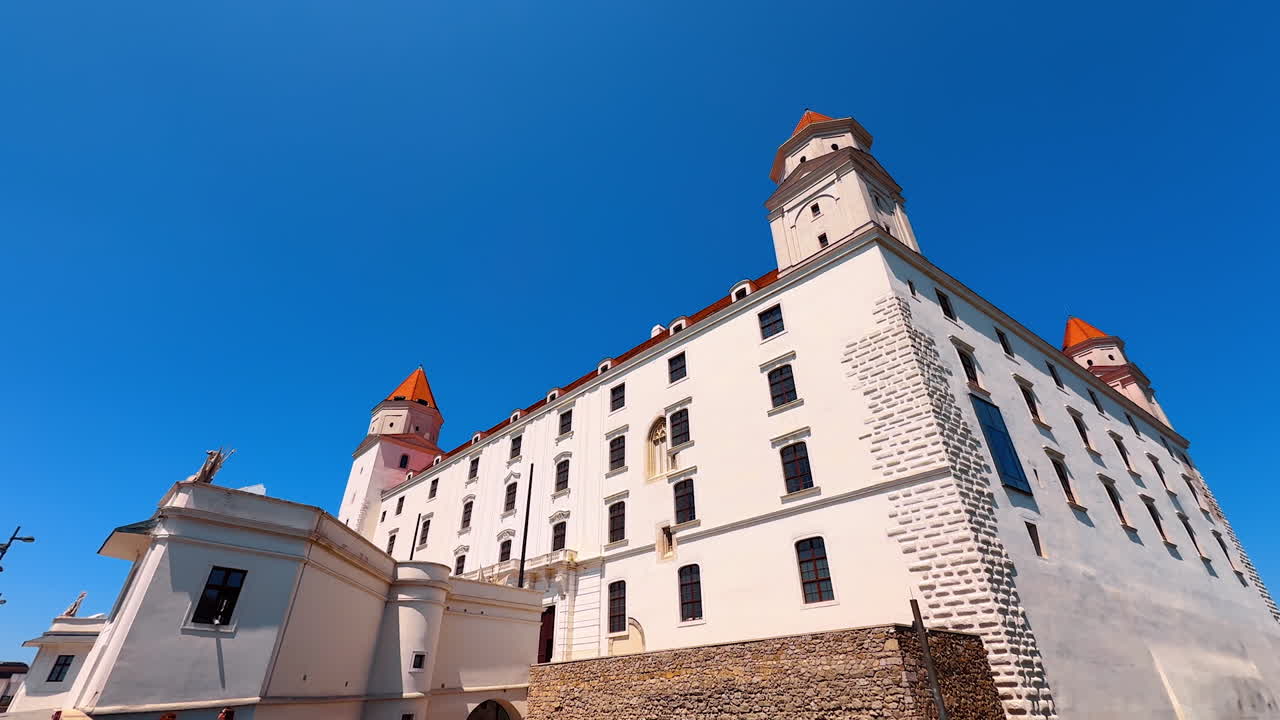Bright sun lights the façade of Bratislava Castle. Low angle view at the Slovak landmark at the backdrop of blue clear sky