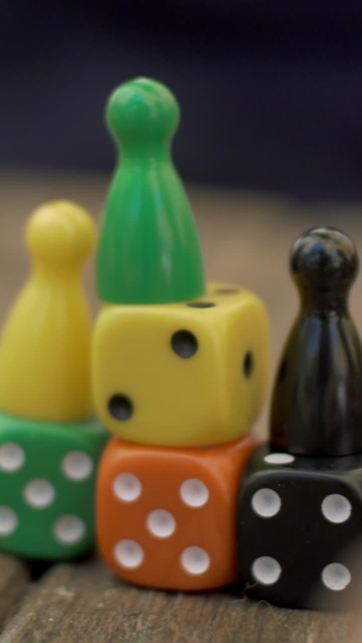 Una mano rovescia pezzi di gioco da tavolo colorati impilati