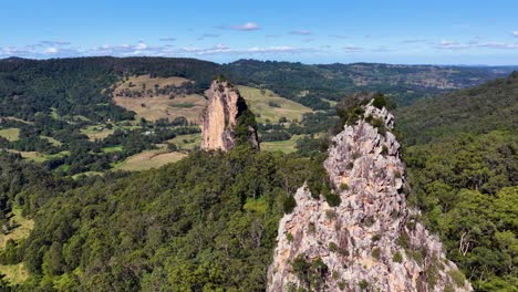 drone footage captures the rugged beauty of nimbin rocks, showcasing lush greenery and striking rock formations under clear skies