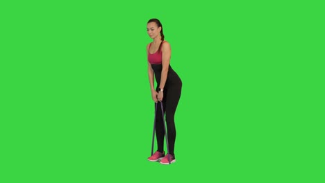 mujer entrenando latissimus con una banda de resistencia de goma en una pantalla verde, llave de croma