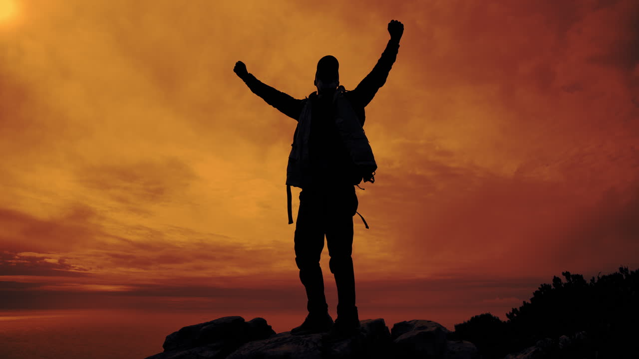 Silhouette of a man celebrating success at sunset
