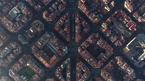 High-angle-view-of-building-in-city-lit-by-low-sun.-Top-down-shot-of-streets-and-blocks-of-houses.-Barcelona,-Spain
