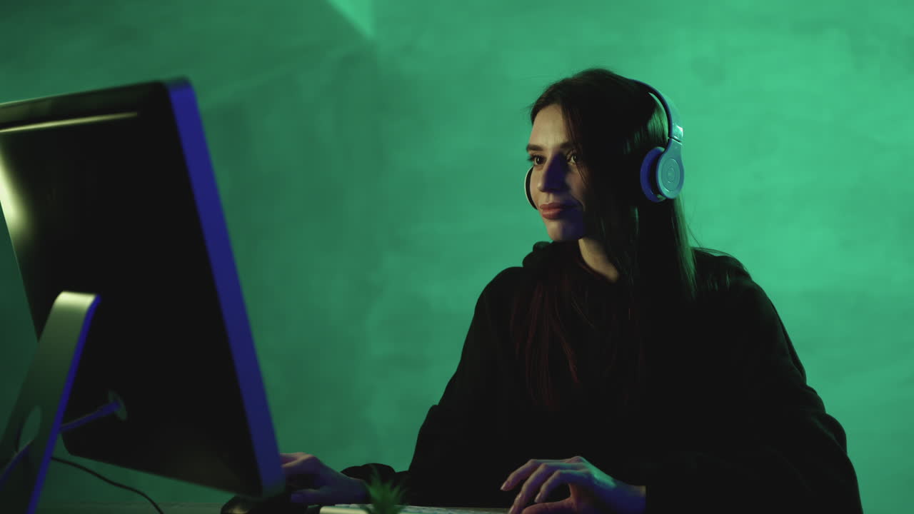 화려 한 배경 에 컴퓨터 와 무선 헤드폰 을 들고 일 하는 행복 한 여자