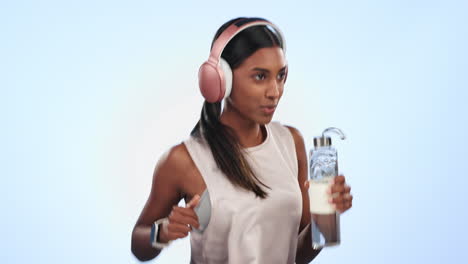 Sports,-headphones-and-woman-running-in-studio