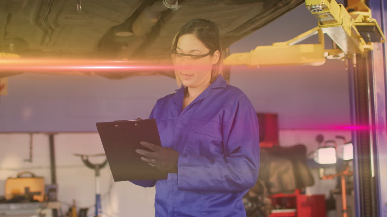 Female mechanic holding clipboard inspecting car chassis in auto repair shop showing animated chart