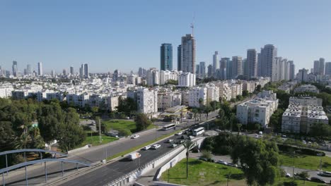 View-of-an-intersection-surrounded-by-trees,-gardens,-and-urban-residential-towers---Parallax-shot