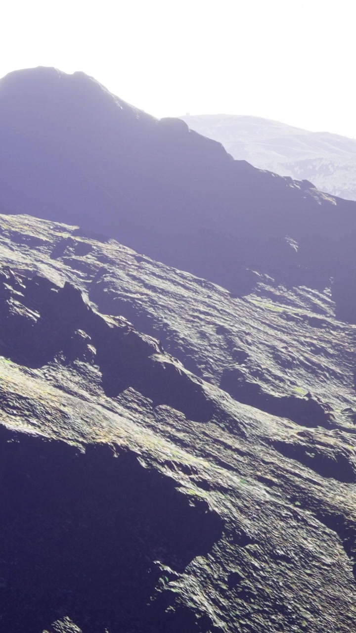 Vista maestosa di montagne aspre rivelata sotto la luce soffusa del sole all'alba.
