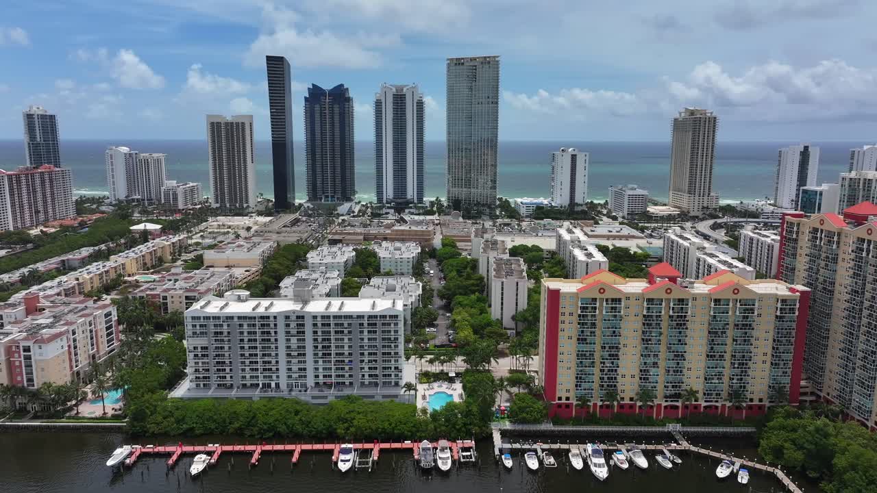 Aerial view of a coastal city with skyscrapers, residential buildings, and a marina