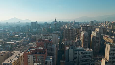 sunlight hits santiago skyline as mist floats over mountains in background