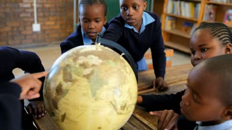 Schoolkids-using-globe-in-classroom-at-school-4k