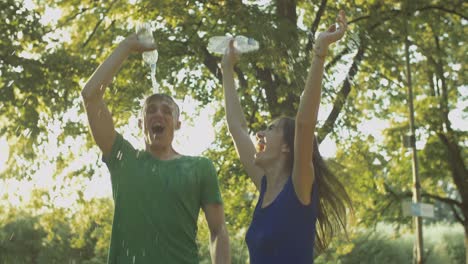 excited couple runners pouring water over themselves