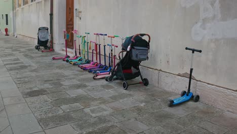 Scooters-Y-Cochecitos-Alineados-En-El-Callejón-De-Venecia,-Italia