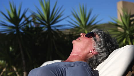 mature woman sunbathing in a deckchair