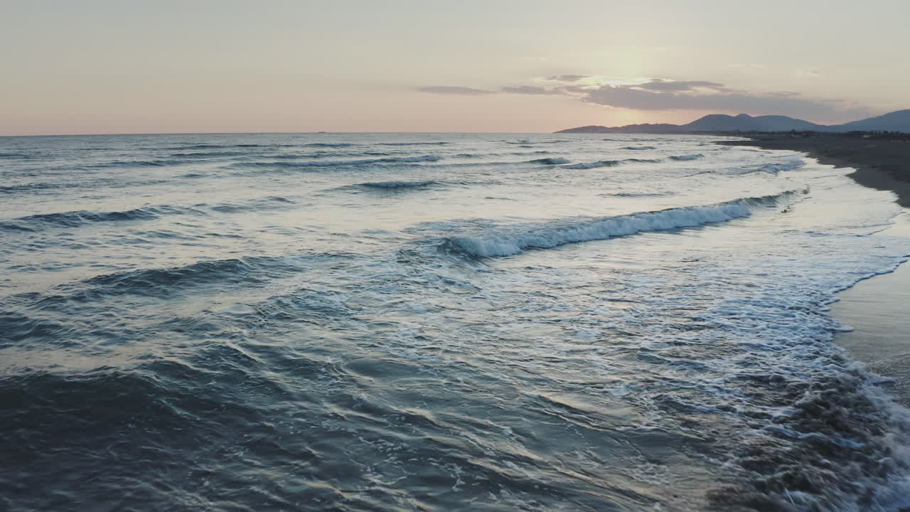 Le onde della spiaggia al tramonto